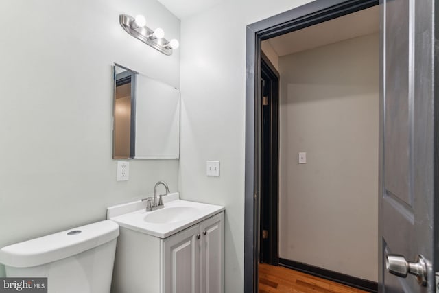 bathroom featuring vanity, wood-type flooring, and toilet