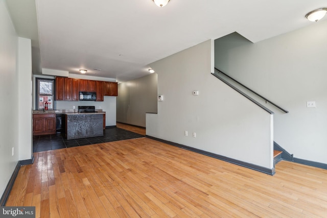 unfurnished living room featuring hardwood / wood-style floors and sink