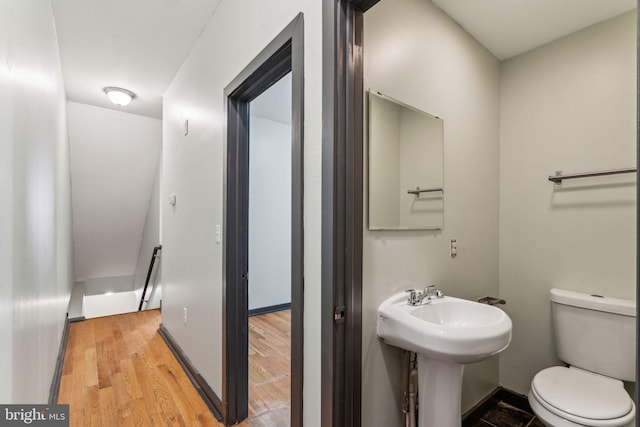 bathroom with hardwood / wood-style flooring, sink, and toilet