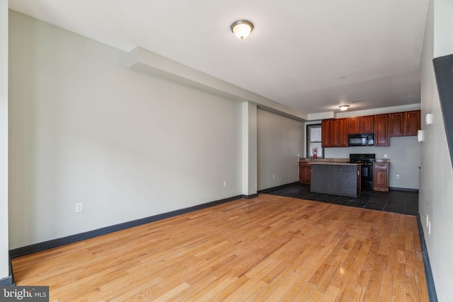 kitchen with dark hardwood / wood-style floors and black appliances