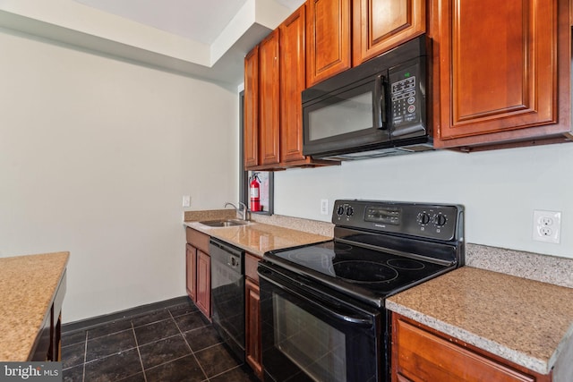 kitchen with dark tile patterned floors, light stone countertops, sink, and black appliances