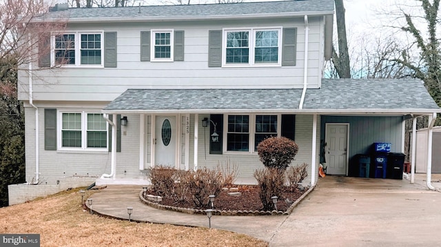 view of front of property with driveway, a shingled roof, and brick siding