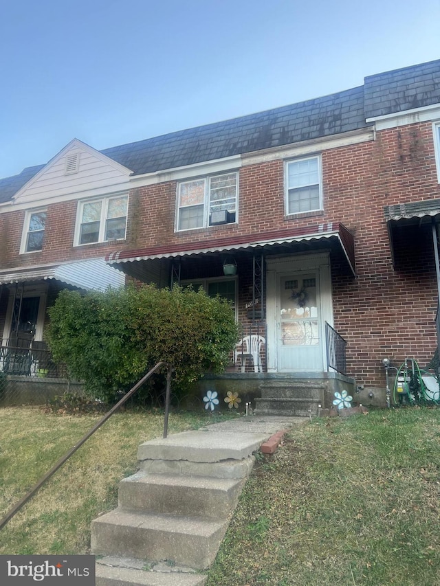 multi unit property featuring a front lawn and covered porch