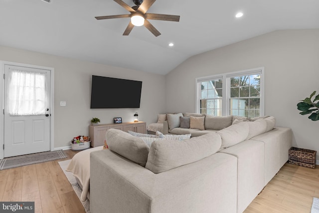 living room featuring lofted ceiling, light hardwood / wood-style flooring, and ceiling fan