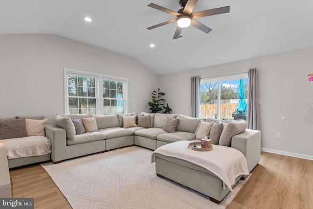 living room featuring ceiling fan, vaulted ceiling, and light hardwood / wood-style flooring