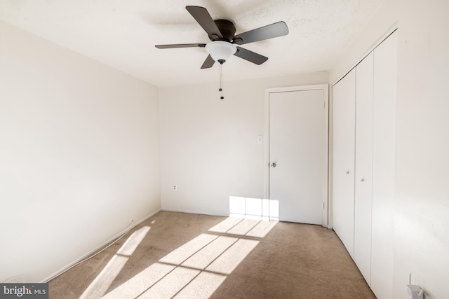 unfurnished room featuring light carpet and ceiling fan