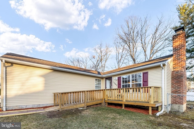 back of house with a yard, a chimney, and a wooden deck