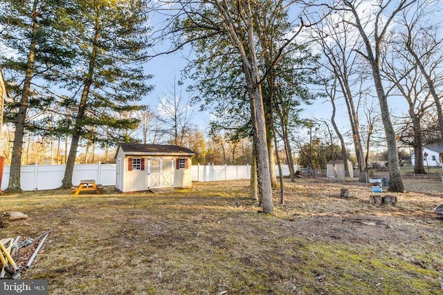 view of yard with an outbuilding, a storage shed, and a fenced backyard