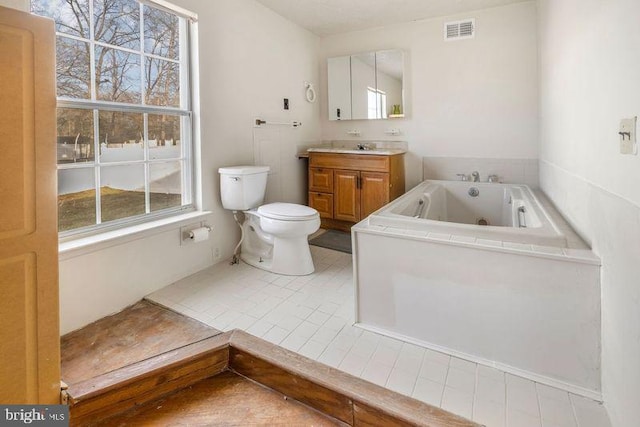 full bathroom with visible vents, toilet, a tub with jets, tile patterned flooring, and vanity