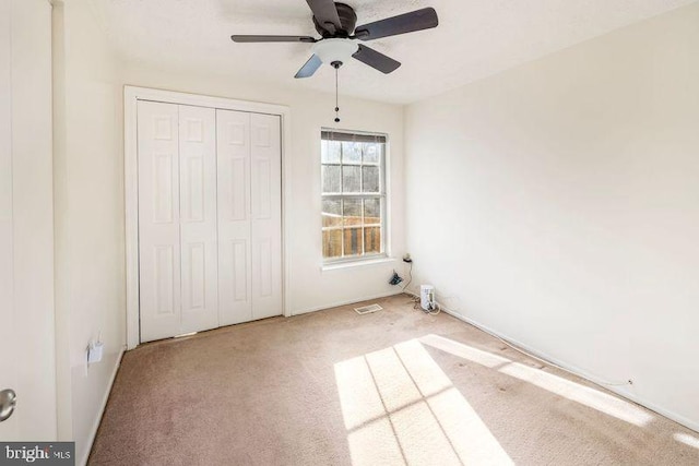 unfurnished bedroom with carpet floors, a ceiling fan, and a closet