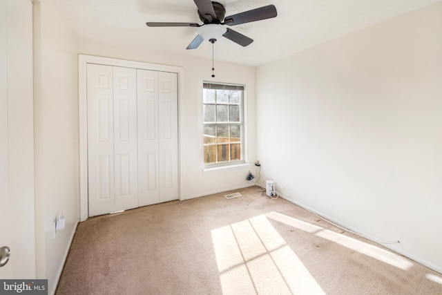 unfurnished bedroom featuring a ceiling fan, a closet, carpet flooring, and baseboards