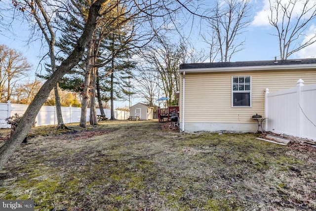 view of yard with an outbuilding, a storage shed, and fence