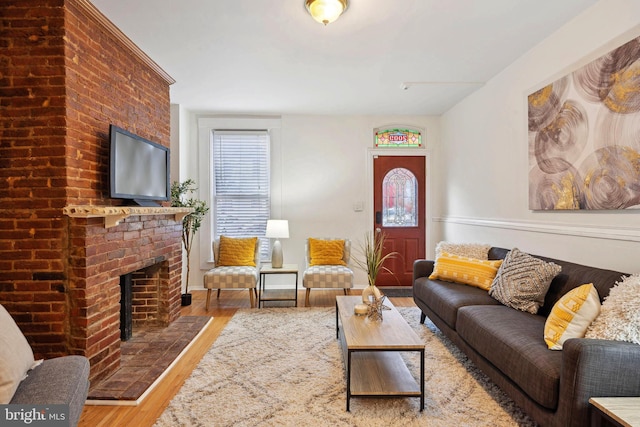 living area featuring a fireplace, wood finished floors, and a wealth of natural light