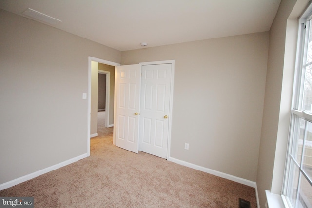 unfurnished bedroom featuring light carpet