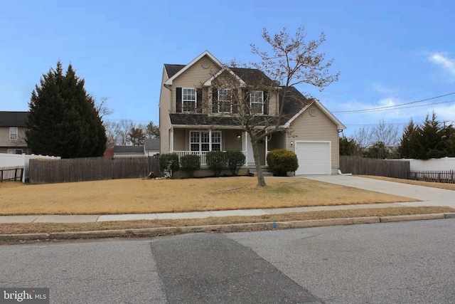 front of property featuring a garage, a front lawn, and covered porch