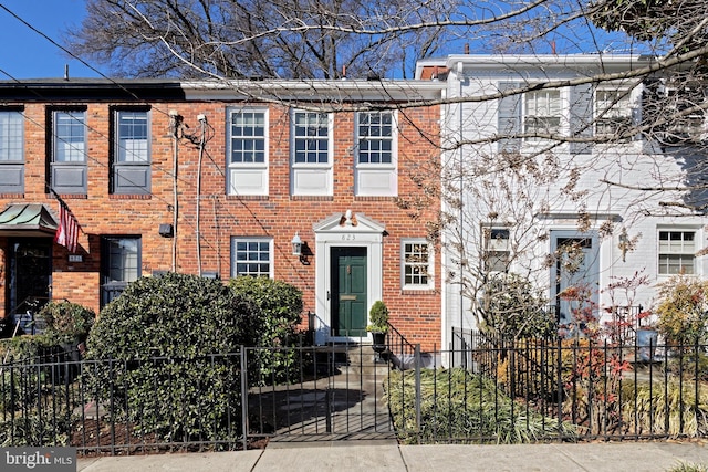 multi unit property with a fenced front yard and brick siding