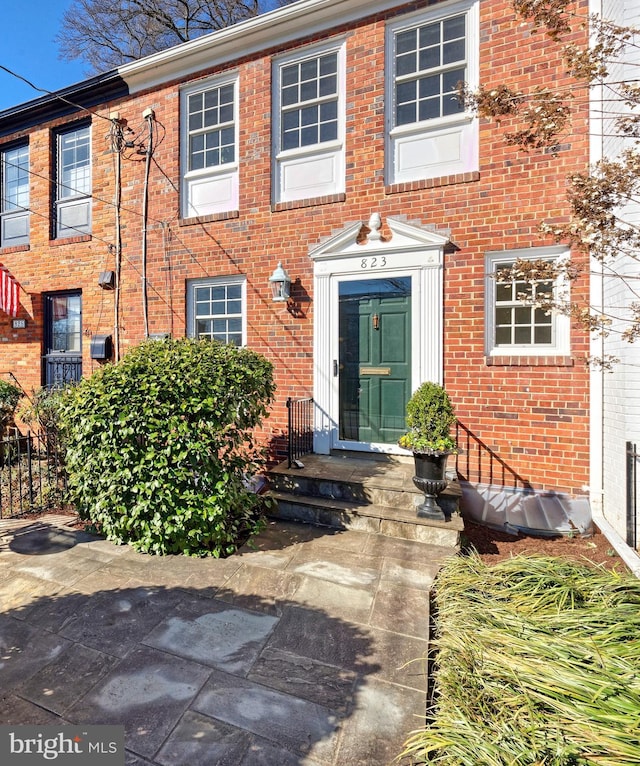 view of exterior entry with brick siding