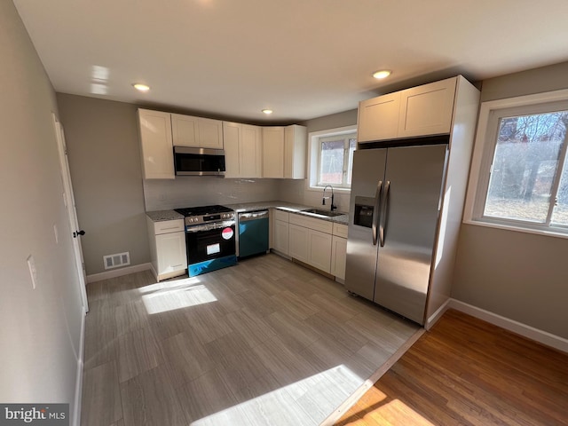 kitchen with sink, stainless steel appliances, and white cabinets