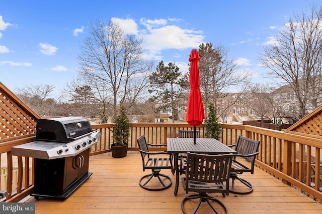 wooden terrace with outdoor dining space and area for grilling