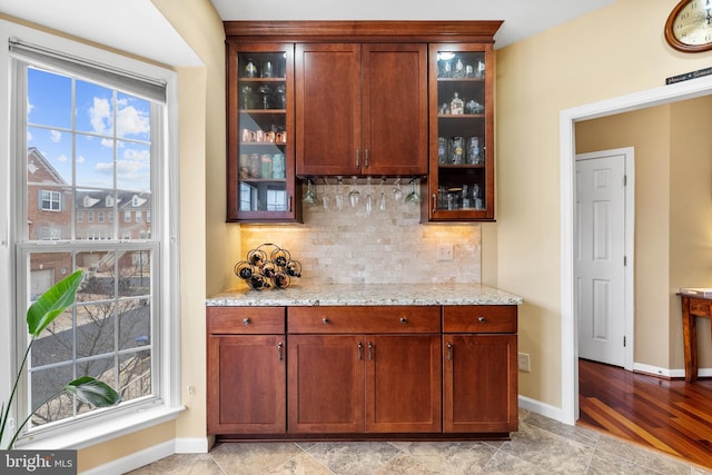 bar featuring a dry bar, baseboards, and decorative backsplash