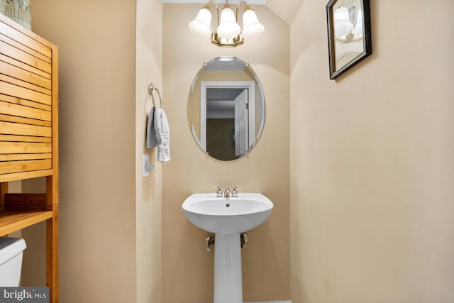 bathroom featuring toilet and an inviting chandelier