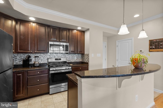 kitchen with a center island, decorative light fixtures, backsplash, appliances with stainless steel finishes, and a breakfast bar area