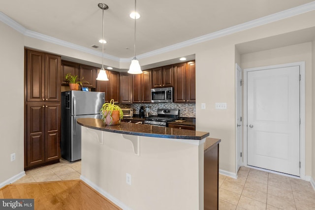 kitchen with stainless steel appliances, decorative light fixtures, a breakfast bar, a kitchen island, and dark stone countertops