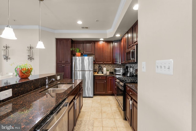 kitchen featuring sink, dark stone counters, decorative light fixtures, stainless steel appliances, and decorative backsplash