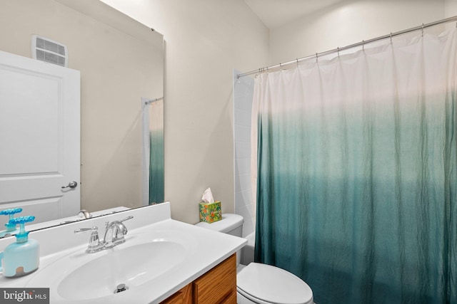 bathroom featuring vanity, toilet, and walk in shower