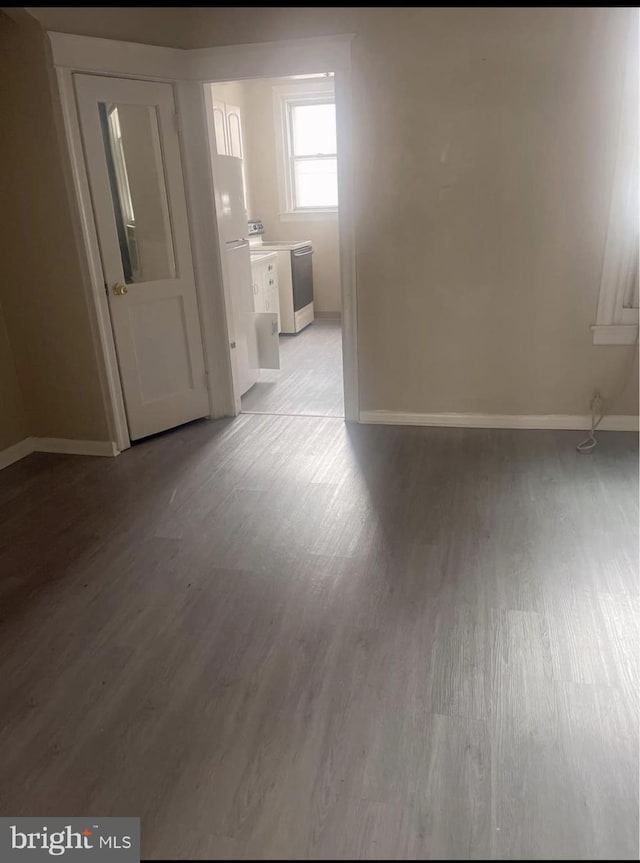 empty room with washer / dryer and light wood-type flooring