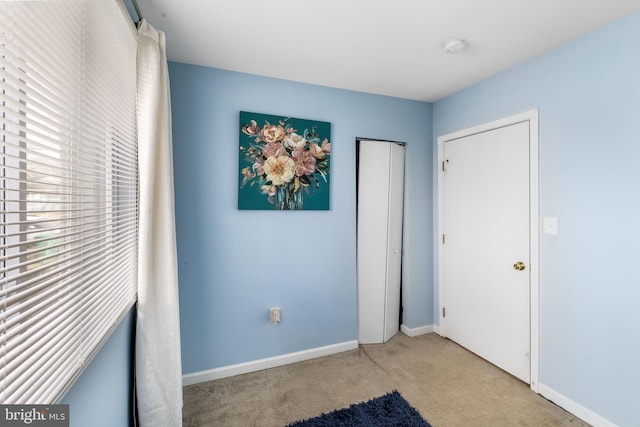 unfurnished bedroom featuring a closet, baseboards, and carpet flooring