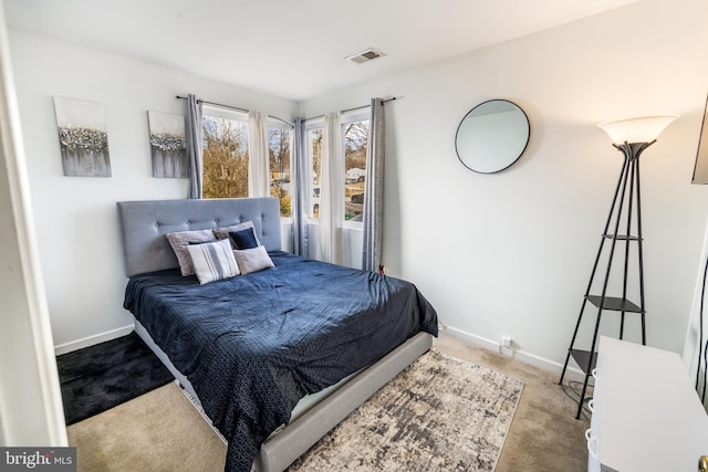 carpeted bedroom with visible vents and baseboards