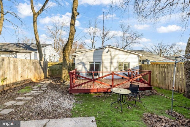 back of property featuring a fenced backyard, a yard, and a deck