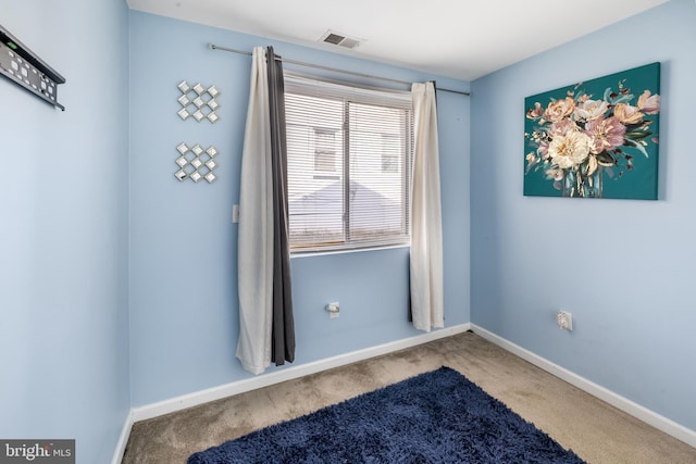 unfurnished room featuring carpet flooring, visible vents, and baseboards