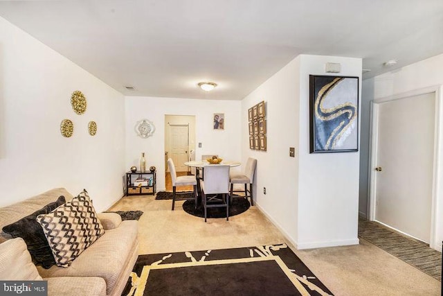 living room featuring light carpet and baseboards