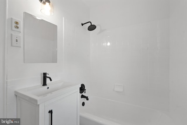 bathroom featuring tiled shower / bath and vanity