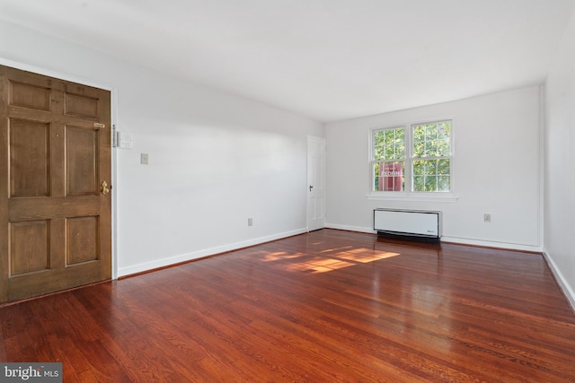 unfurnished room with radiator heating unit and dark hardwood / wood-style floors