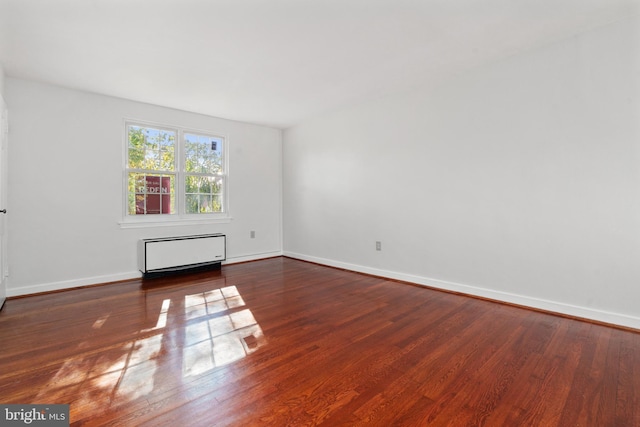 unfurnished room featuring dark hardwood / wood-style floors and radiator