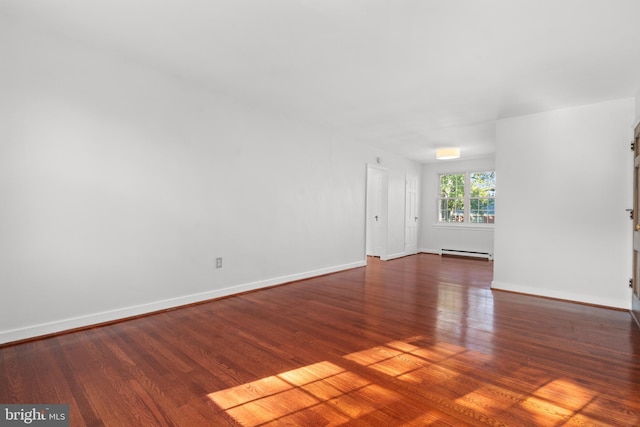 unfurnished living room featuring a baseboard heating unit and dark wood-type flooring