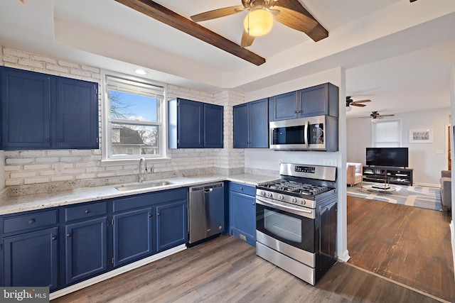 kitchen featuring sink, blue cabinetry, dark hardwood / wood-style floors, and appliances with stainless steel finishes