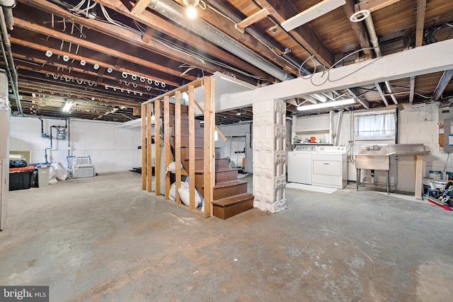 basement featuring sink, washer and clothes dryer, and electric panel