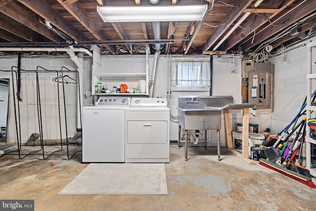 basement with sink, washing machine and dryer, and electric panel