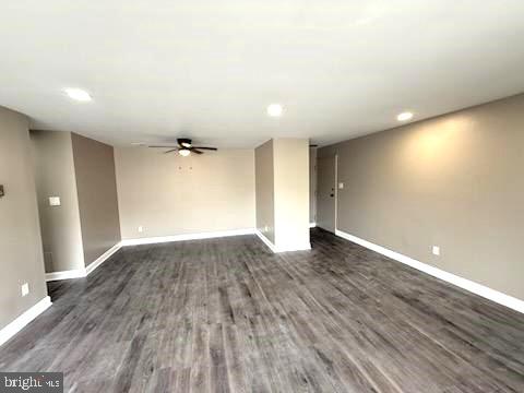 empty room featuring dark wood-type flooring and ceiling fan