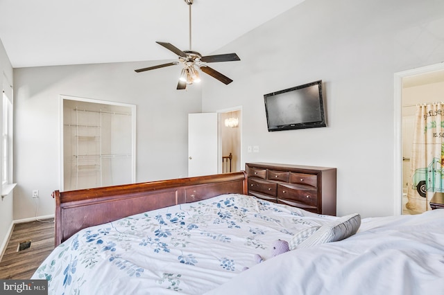 bedroom with wood finished floors, baseboards, visible vents, vaulted ceiling, and a closet