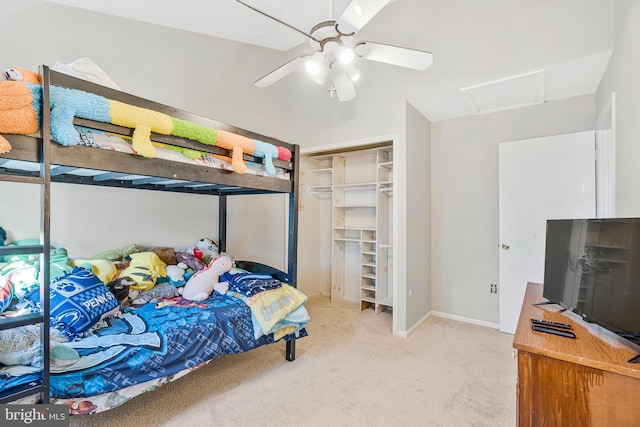 carpeted bedroom with attic access, a ceiling fan, a closet, and baseboards