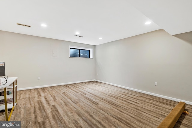 below grade area featuring visible vents, baseboards, and light wood finished floors