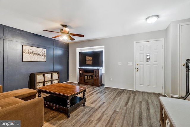 living area featuring wood finished floors and a ceiling fan