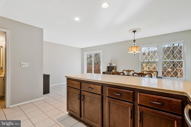 kitchen with baseboards, pendant lighting, light countertops, light tile patterned floors, and recessed lighting