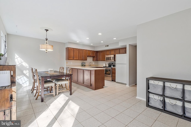 kitchen with baseboards, light countertops, recessed lighting, appliances with stainless steel finishes, and a peninsula