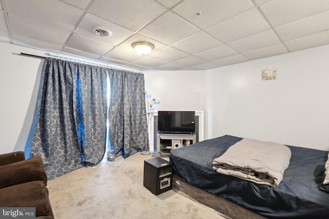 bedroom with visible vents, a drop ceiling, and carpet flooring